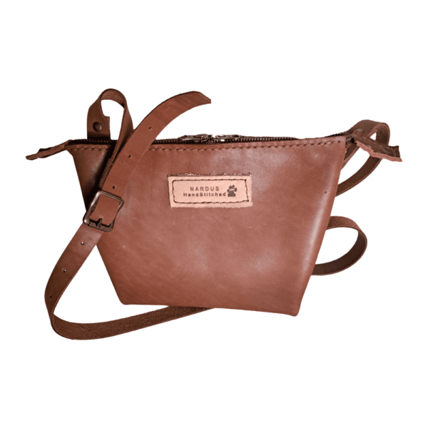 A leather sling bag is a type of bag designed to be worn across the body or over one shoulder, with the strap looping over one side of the body and the bag resting on the opposite hip or back.